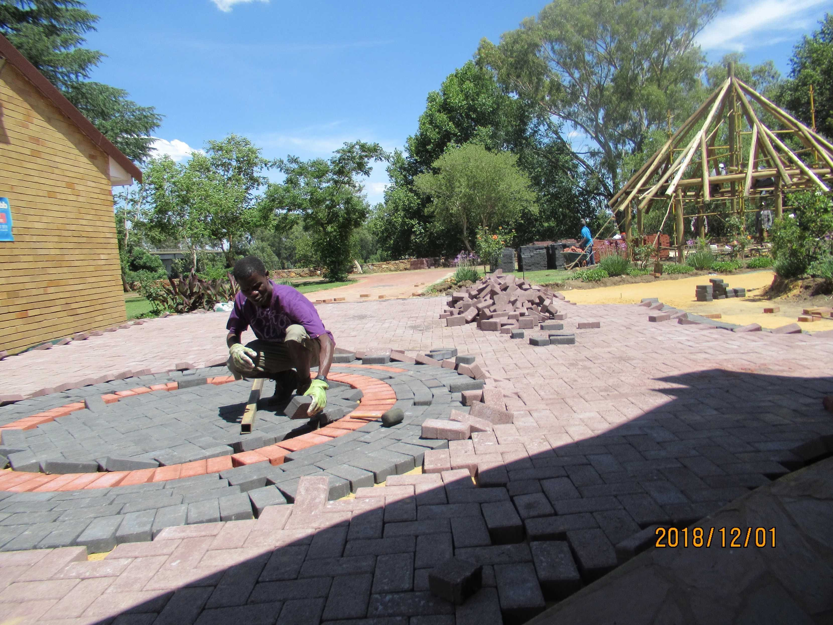 Father Clement laying some bricks for the outside paving of La Verna Catholic Church 